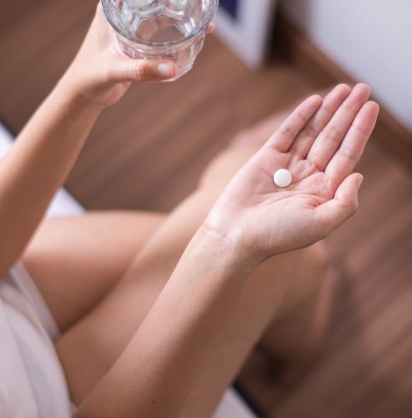 Overview shot of patient holding a glass of water an oral conscious sedation pill