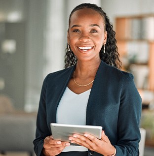 Smiling woman holding tablet in office