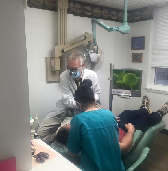 Experienced dentist and team member treating dental patient