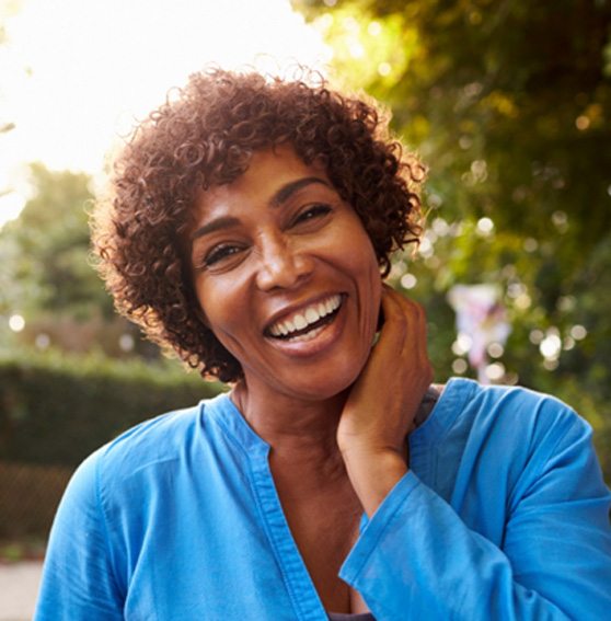 a smiling woman standing outside