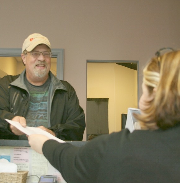 Dental patient giving team member dental insurance forms