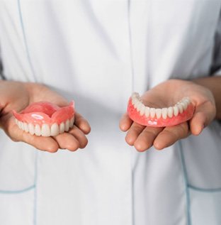 Dentist holding full dentures in Kittanning, PA