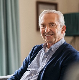 Senior man sitting on a couch and smiling