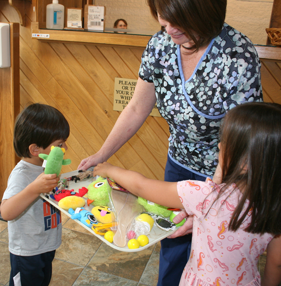 Kids receiving fun prizes after pain relieving pulp therapy treatment