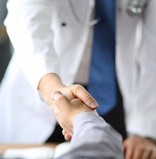 Close-up of patient shaking hands with dentist