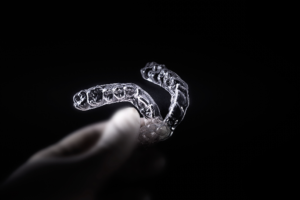 Hand holding clear aligners