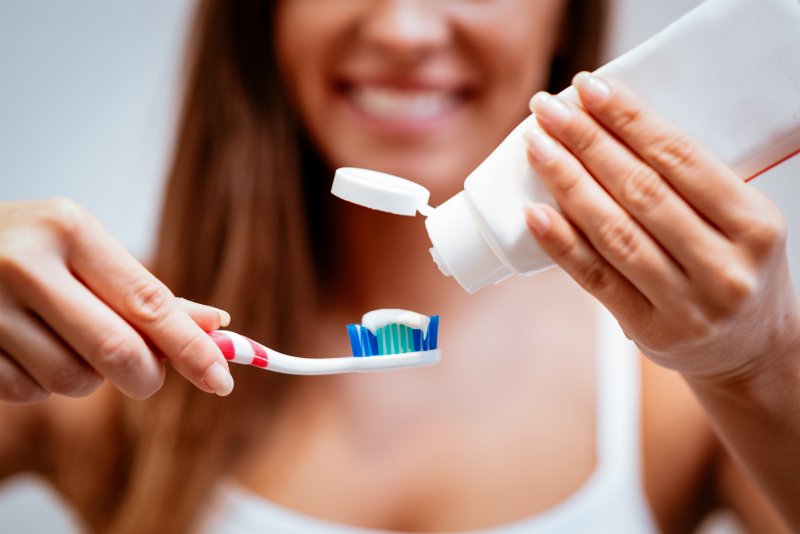 Woman squeezing toothpaste onto her toothbrush