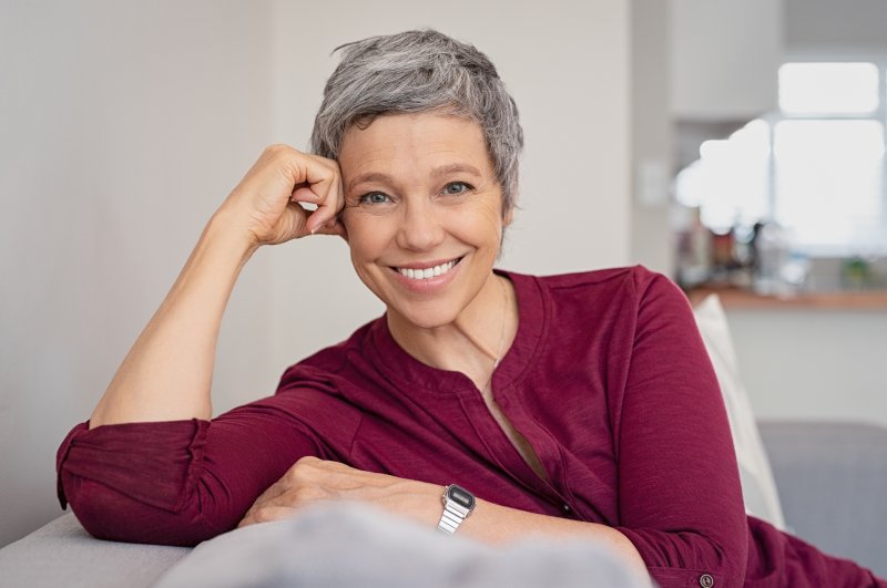 Senior woman sitting on couch and smiling