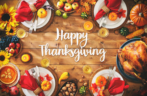 “Happy Thanksgiving” surrounded by food on wooden table