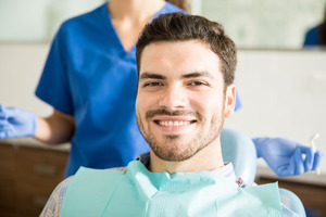 Dental patient sitting and smiling after a checkup and cleaning