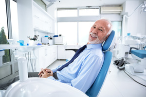 Older man with tie sitting in dental chair